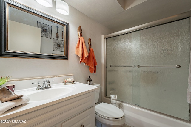 full bathroom featuring bath / shower combo with glass door, toilet, and vanity