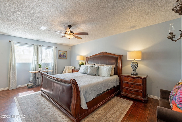 bedroom with a ceiling fan, baseboards, wood-type flooring, and a textured ceiling