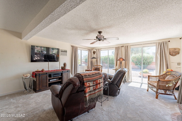 living room with baseboards, carpet floors, a textured ceiling, and a ceiling fan