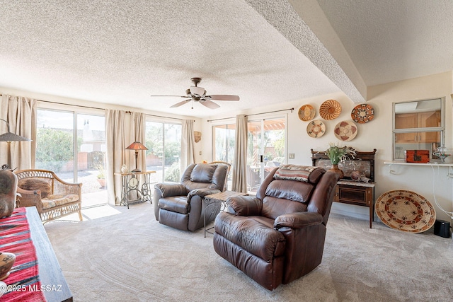 carpeted living area featuring a textured ceiling and ceiling fan