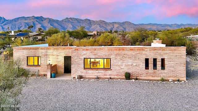 view of front facade with a mountain view and a chimney