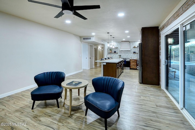 sitting room featuring visible vents, baseboards, a ceiling fan, and light wood finished floors