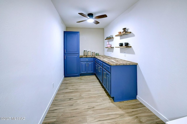 bar featuring baseboards, light wood-style flooring, and a ceiling fan