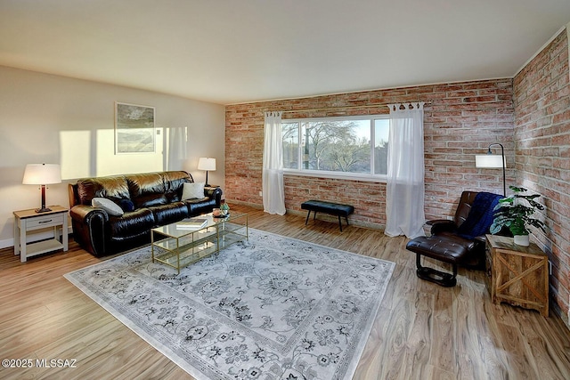 living room featuring wood finished floors and brick wall