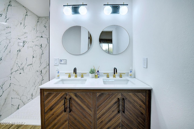 bathroom featuring double vanity, walk in shower, and a sink