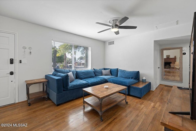 living area with visible vents, a ceiling fan, and wood-type flooring