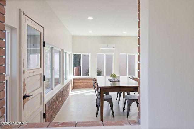 dining area featuring brick wall, a wall mounted air conditioner, and recessed lighting