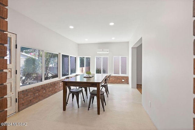 dining area featuring a wall unit AC, brick wall, finished concrete floors, and recessed lighting