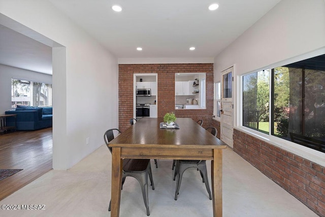 dining space featuring recessed lighting and brick wall