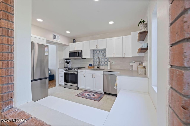 kitchen featuring light countertops, white cabinets, stainless steel appliances, and visible vents