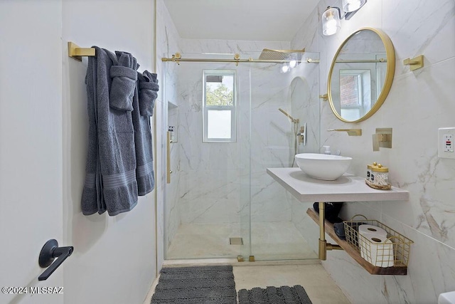 full bathroom with a marble finish shower and a sink
