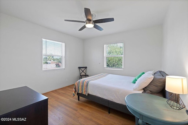 bedroom featuring multiple windows, ceiling fan, and wood finished floors