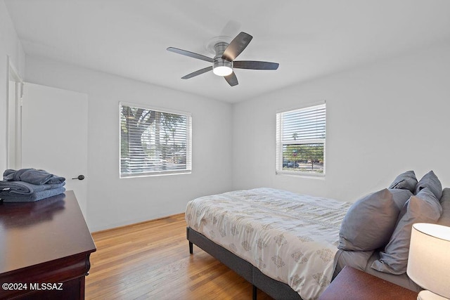 bedroom with multiple windows, light wood-type flooring, and ceiling fan