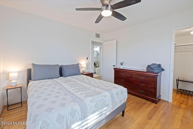 bedroom featuring a closet, a ceiling fan, a spacious closet, light wood-style flooring, and visible vents