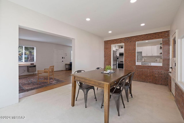 dining area featuring heating unit, light wood-style flooring, brick wall, and recessed lighting