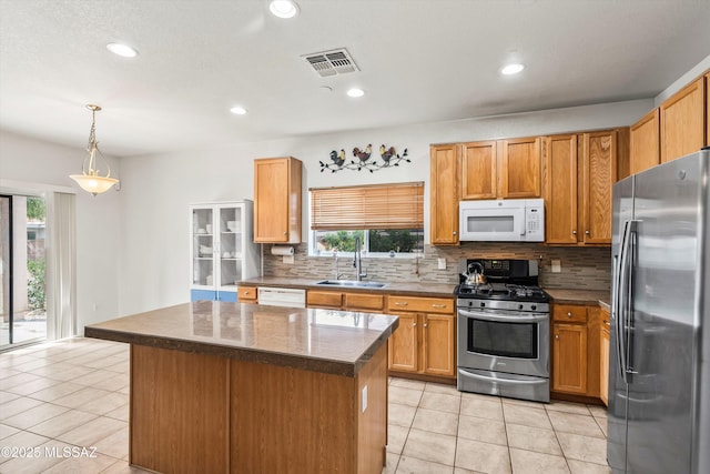 kitchen featuring visible vents, a sink, backsplash, stainless steel appliances, and light tile patterned floors