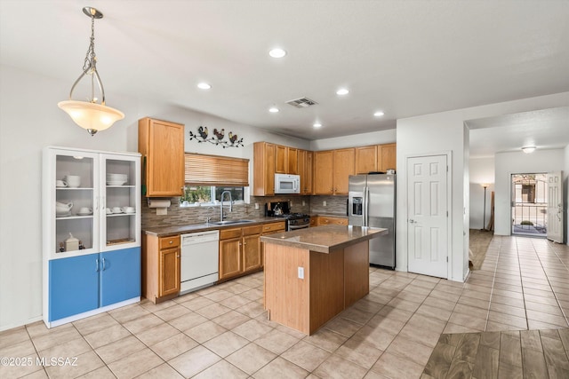 kitchen with visible vents, a sink, tasteful backsplash, a center island, and appliances with stainless steel finishes