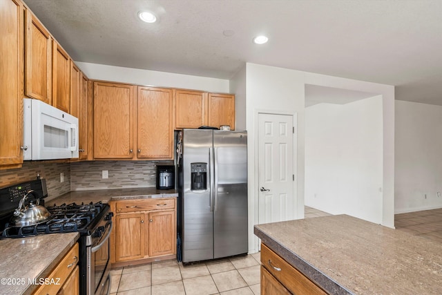 kitchen with light tile patterned floors, recessed lighting, backsplash, and stainless steel appliances