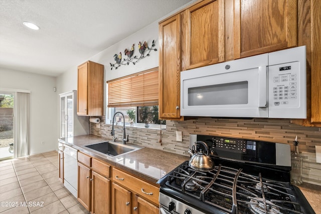 kitchen with white appliances, light tile patterned flooring, plenty of natural light, and a sink