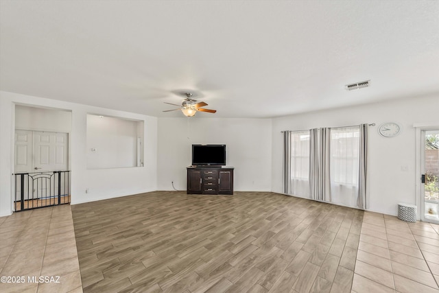 unfurnished living room featuring visible vents, light wood-style flooring, and a ceiling fan