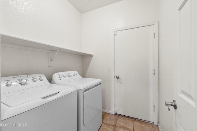 washroom featuring laundry area, light tile patterned flooring, and separate washer and dryer