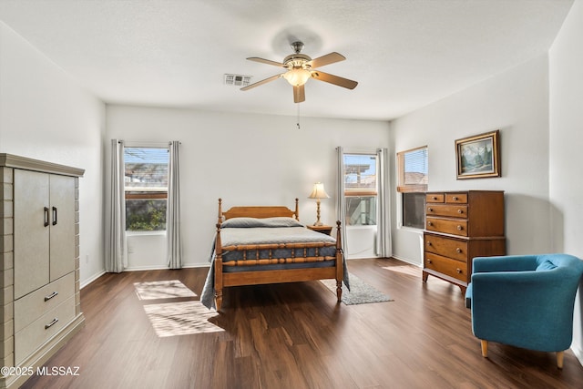 bedroom with visible vents, baseboards, a ceiling fan, and wood finished floors