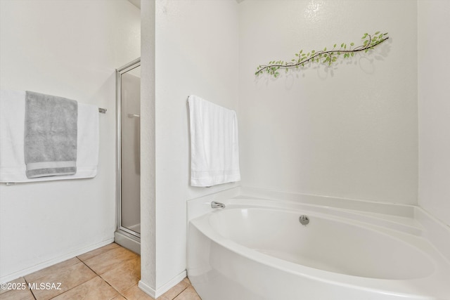 bathroom featuring tile patterned floors, a bath, and a shower stall