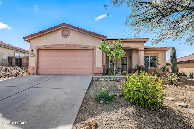 view of front of home with stucco siding, a garage, concrete driveway, and fence