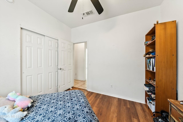 bedroom with visible vents, baseboards, ceiling fan, wood finished floors, and a closet