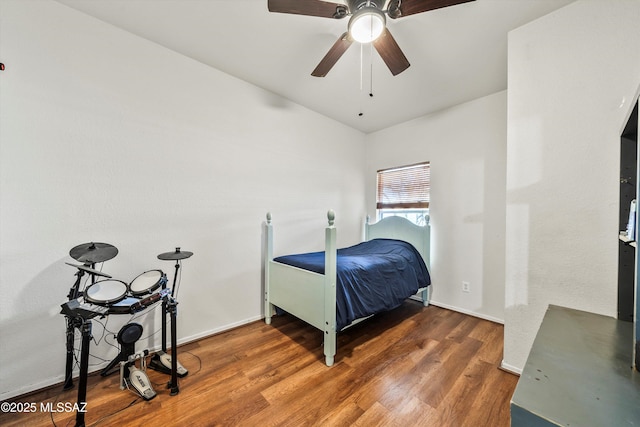 bedroom with a ceiling fan, wood finished floors, and baseboards