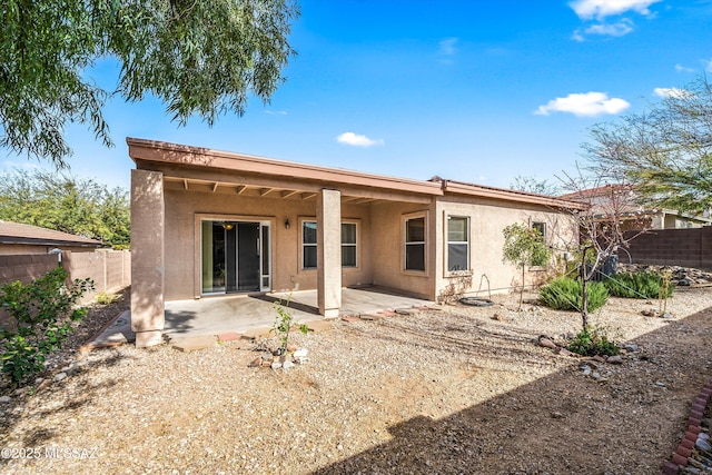 rear view of house with a patio area, stucco siding, and a fenced backyard