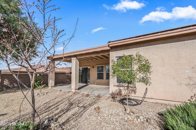 back of house featuring a patio area, stucco siding, and a fenced backyard