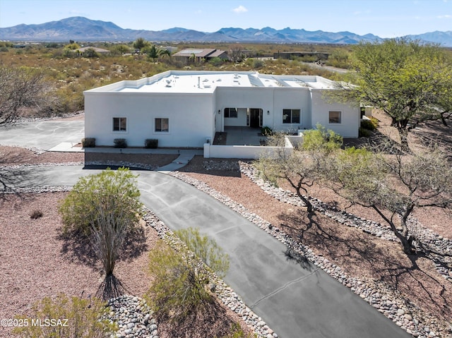 pueblo-style home featuring stucco siding and a mountain view