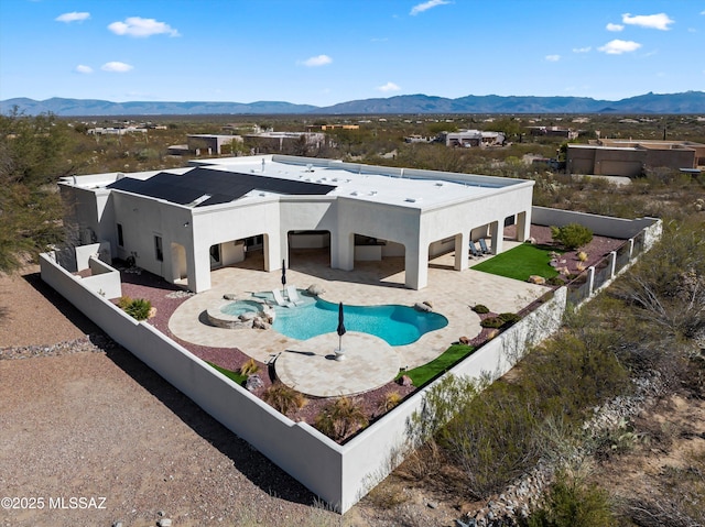 rear view of property with a patio area, a mountain view, a fenced backyard, and stucco siding