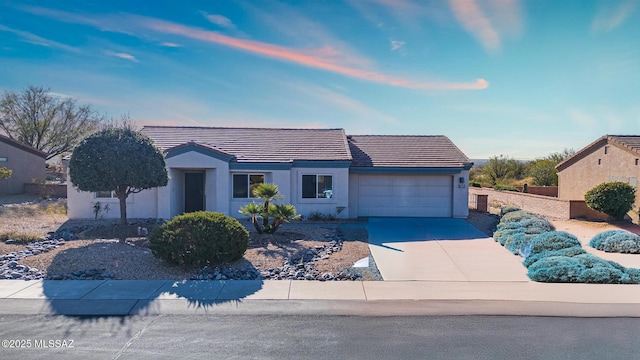 view of front facade with a garage, a tile roof, driveway, and stucco siding