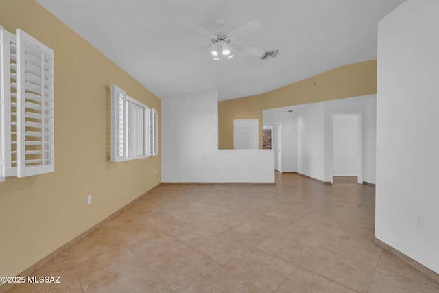 tiled spare room featuring visible vents, lofted ceiling, baseboards, and ceiling fan