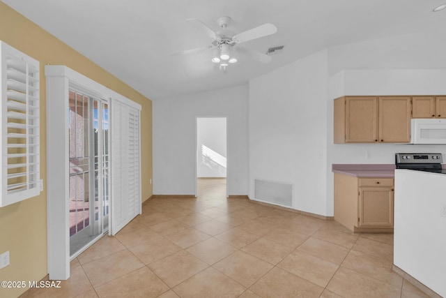 kitchen featuring white microwave, visible vents, a healthy amount of sunlight, and electric stove