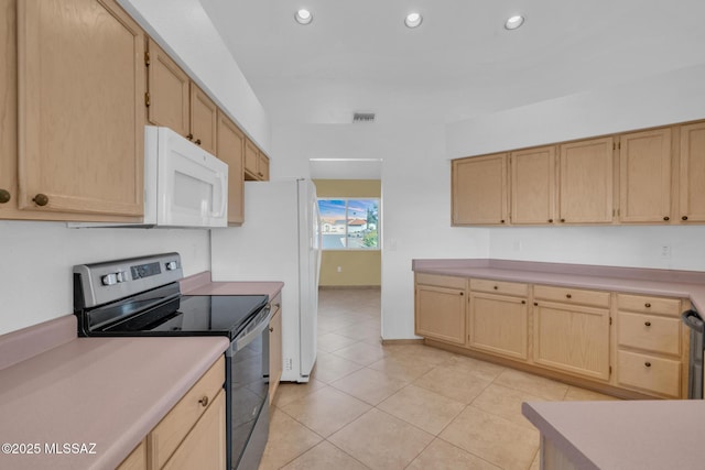 kitchen featuring white microwave, visible vents, light brown cabinets, light countertops, and electric stove