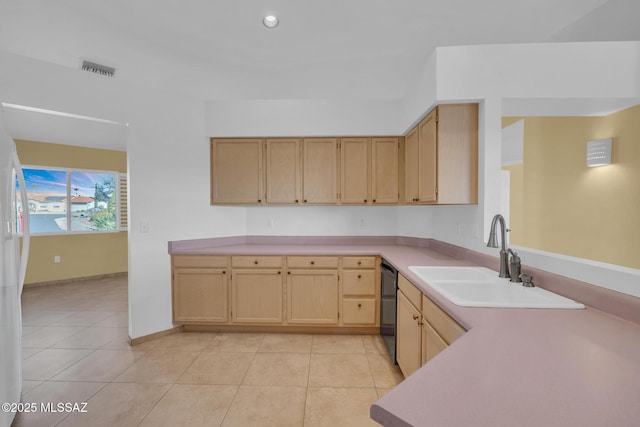 kitchen featuring light tile patterned floors, light brown cabinetry, a sink, light countertops, and black dishwasher