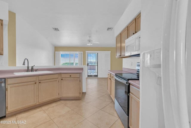 kitchen with a sink, a peninsula, visible vents, and stainless steel appliances