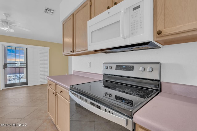 kitchen featuring visible vents, light brown cabinets, stainless steel electric stove, white microwave, and ceiling fan