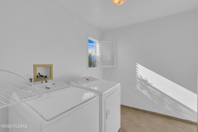 clothes washing area with light tile patterned floors, baseboards, laundry area, and washing machine and clothes dryer