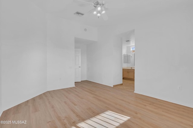 interior space featuring light wood-type flooring, visible vents, and a ceiling fan