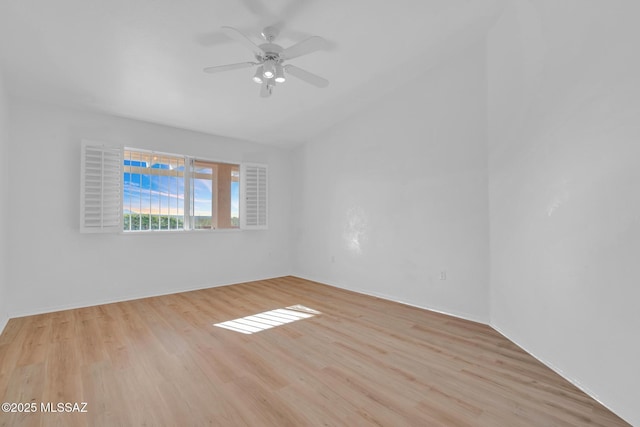 spare room with wood finished floors, a ceiling fan, and vaulted ceiling