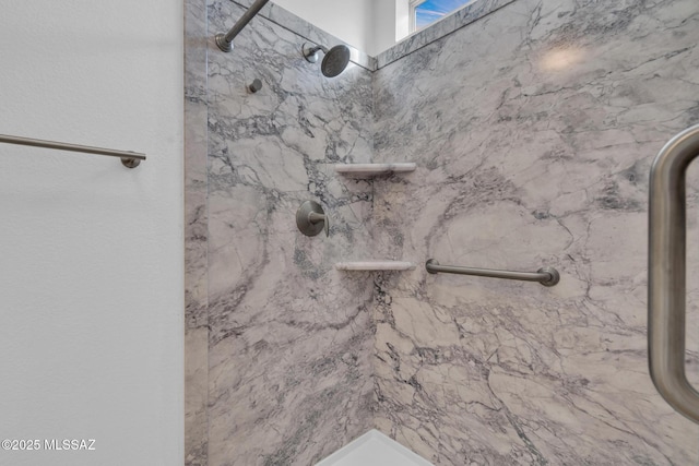 interior details featuring a marble finish shower