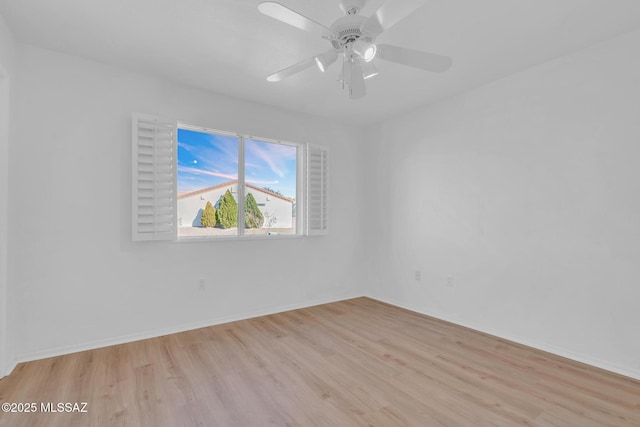 spare room featuring light wood-style floors, baseboards, and ceiling fan