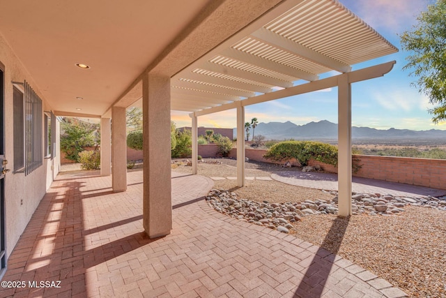 view of patio with a mountain view, fence, and a pergola