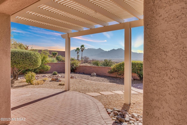 view of patio / terrace with a pergola, a fenced backyard, and a mountain view