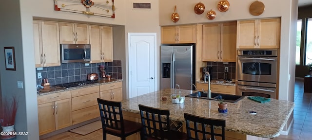16311 S Creosote View Ln, Vail, AZ 85641 - kitchen with stainless steel appliances, light brown cabinetry, a sink, light tile patterned flooring, and tasteful backsplash