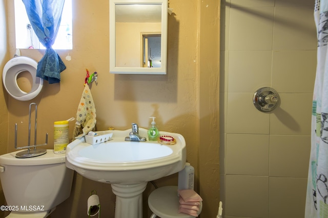 bathroom with toilet and a shower with curtain